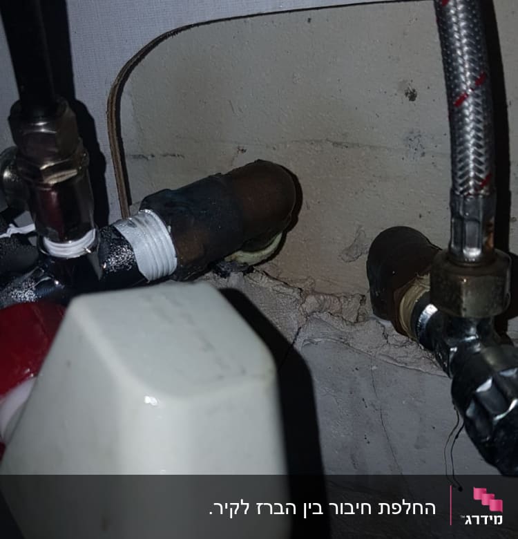 צינורות מתכת מחוברים לקיר עם מחברים
